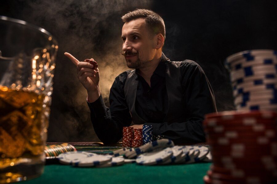 Visuel article Comment gagner au poker : joueur devant une table de jeu avec des jetons posés devant lui.